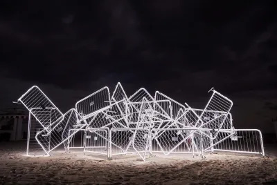 A sculpture consisting of various silver barricades that have been welded together.