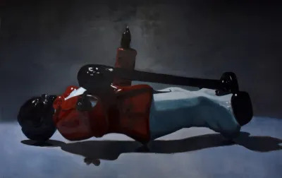 A painting of a Black figurine that is laying on its side.