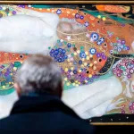 A visitor looks at the painting 