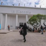 Crowds of people in front of a white columned building with 