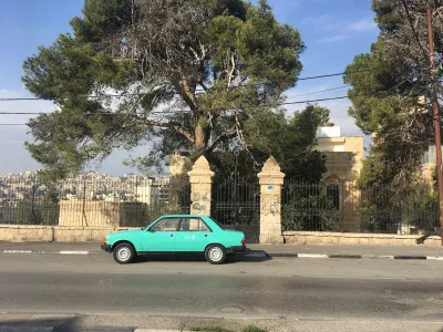 A blue car parked on a city street.