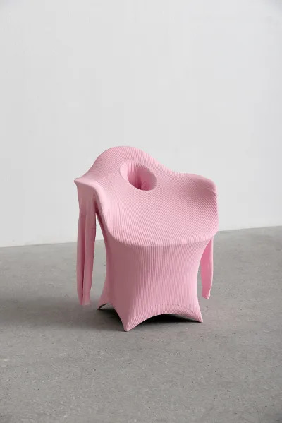 An Eames chair covered in pink fabric.