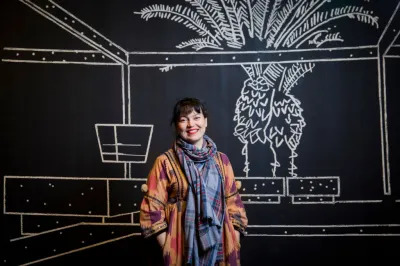 Yto Barrada standing in her exhibition 