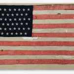 A tattered American flag with white bandages on it.