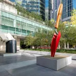 Monumental sculptures of a red garden trowel and a handkerchief.