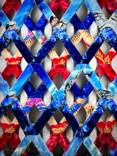 An artwork with a lattice design made of fleece blankets over foam. 