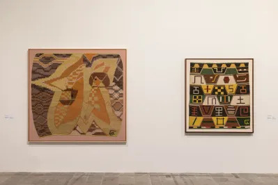 Two wall-hung weavings, one of which features a female figure set against a star.