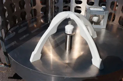A sensor mounted on a circular metal platform is surrounded by a Space Age structure.