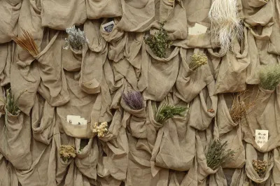 Rows of burlap sacks that hold dried flowers and texts of various kinds.