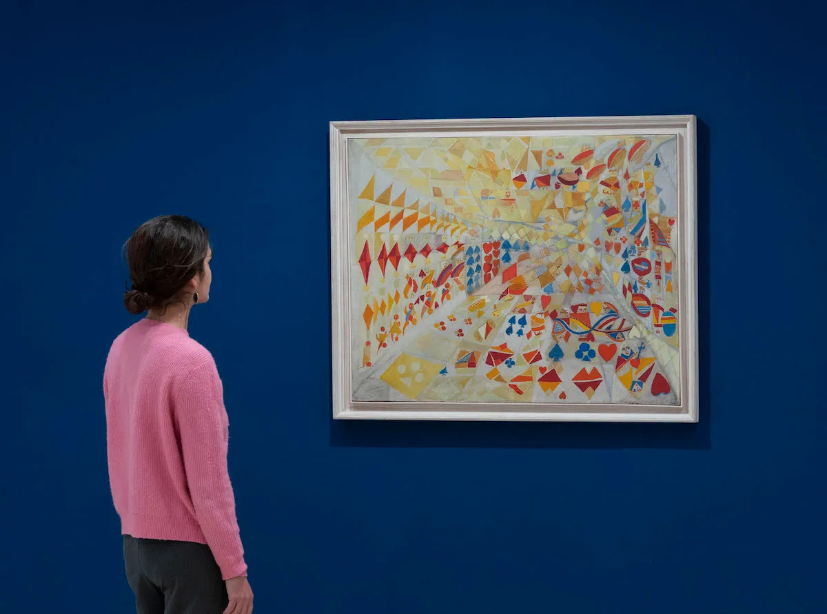 A woman looking at an abstract painting.