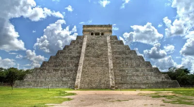 Kukulkan pyramid in Chichen Itza, is one of the touristic attractions of the area. Green vegetation and blue sky in this energetic place