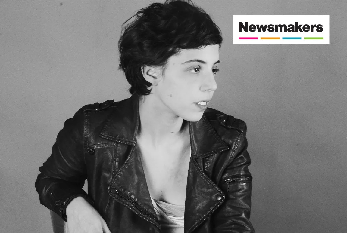 A black and white photo of a woman in a leather jacket and short hair.
