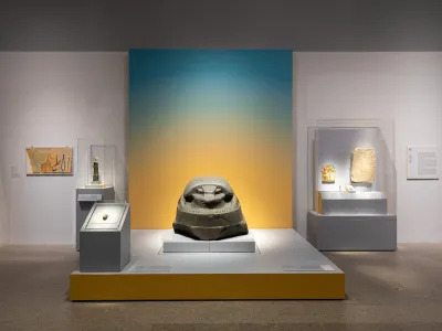 A sculpture of a scarab on a raised section a gallery.