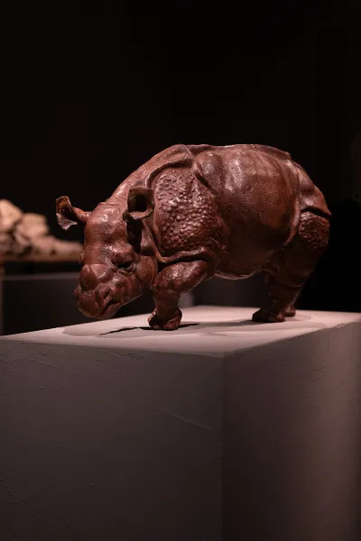 sculpture of a brown rhinoceros on a plinth