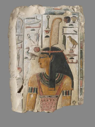 A painted relief of a woman with a feather in her crown. She is surrounded by hieroglyphics.