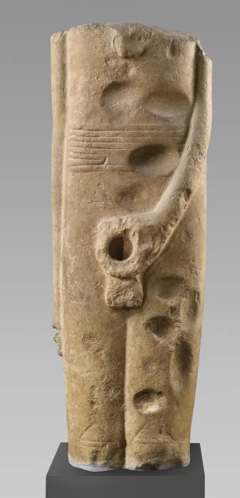 A partially eroded statue of a headless figure gripping his penis. The phallus itself has been broken off.