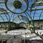 A glass-domed building with fair booths inside it.