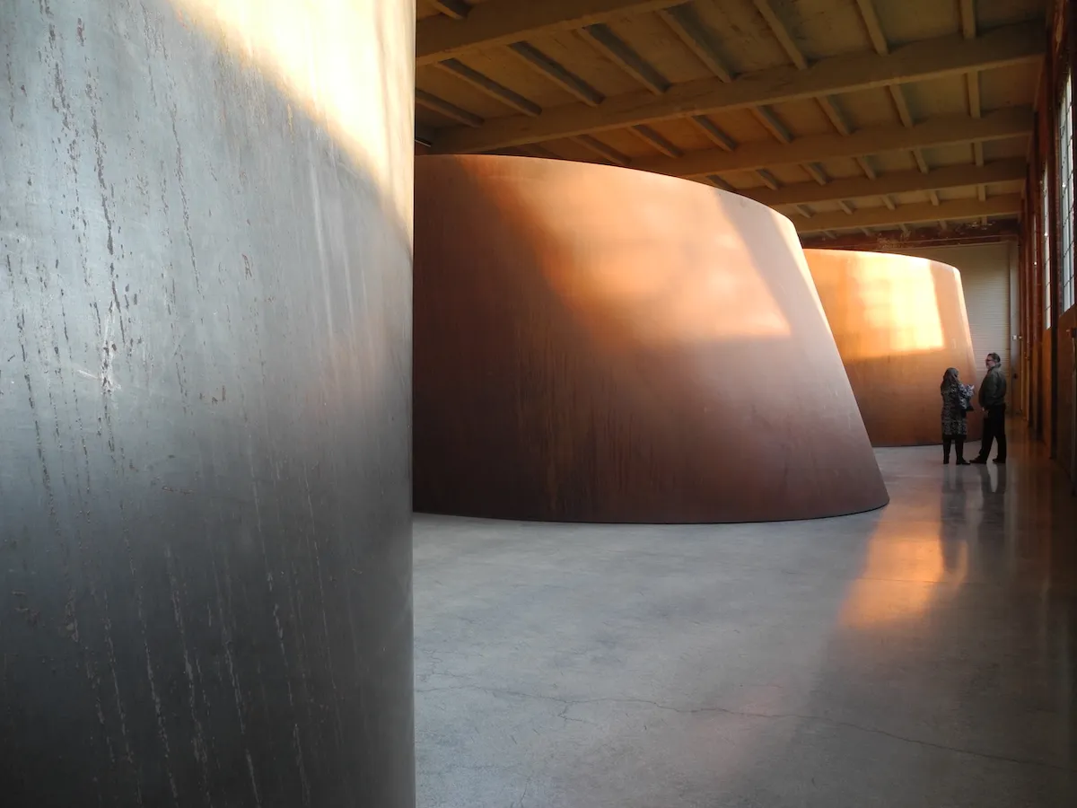 Curving sculptures formed from steel in a gallery.