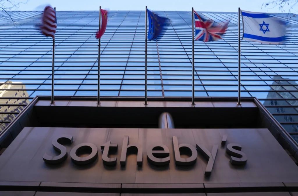 A skyscraper with flags and a sign reading Sotheby
